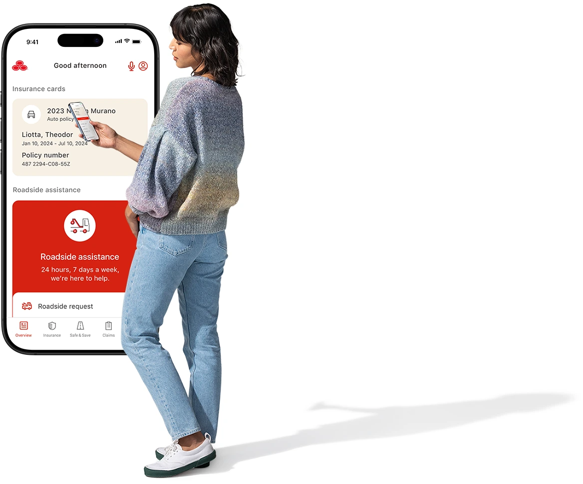 Standing next to an enlarged image of the State Farm app, a young lady checks her smartphone.